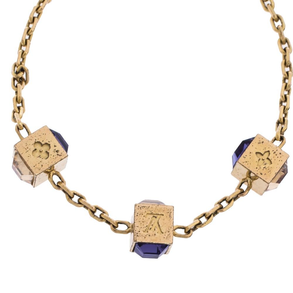Artfully made from gold-tone metal, this flawless bracelet by Louis Vuitton can be your next prized possession. Featuring a gorgeous set of 3 cubes with monogram engravings and crystals, the design has been finished with the signature LV logo and a