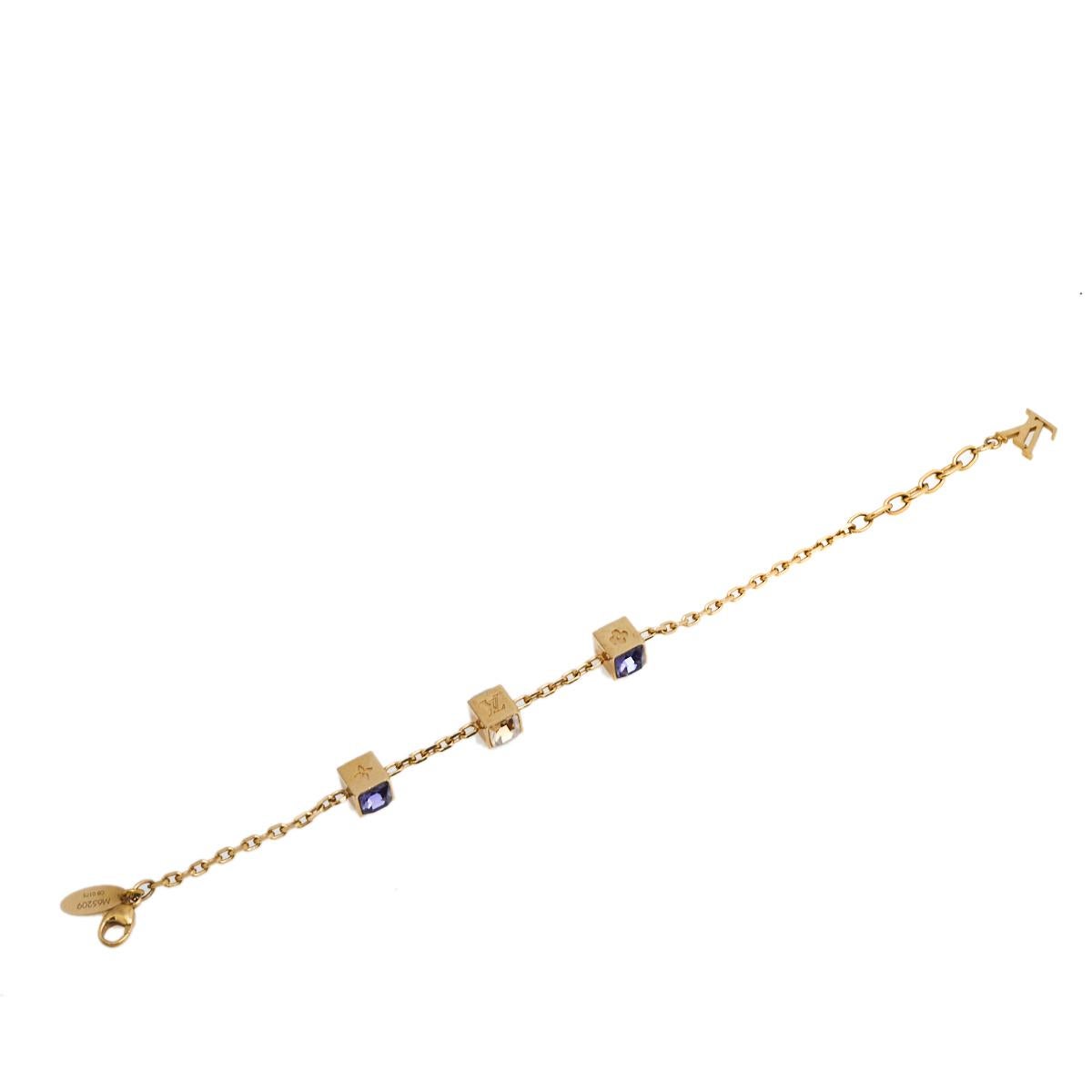 Artfully made from gold-tone metal, this flawless bracelet by Louis Vuitton can be your next prized possession. Featuring a gorgeous set of 3 cubes synonymous with the Gamble theme with monogram engravings and crystals, the design has been finished