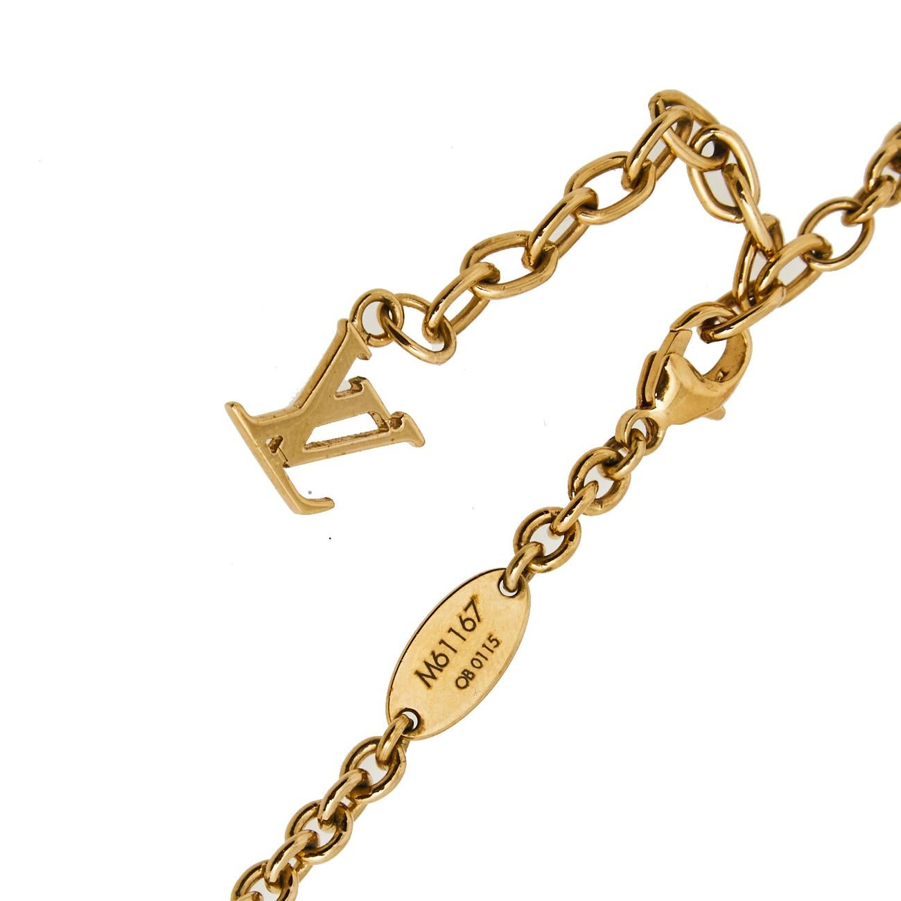 Feel like a modern queen every time you flaunt this Louis Vuitton necklace. It has been crafted from gold-tone metal and designed with an LV logo charm and three cubes with monogram engravings and crystals embedded in them. The piece is complete