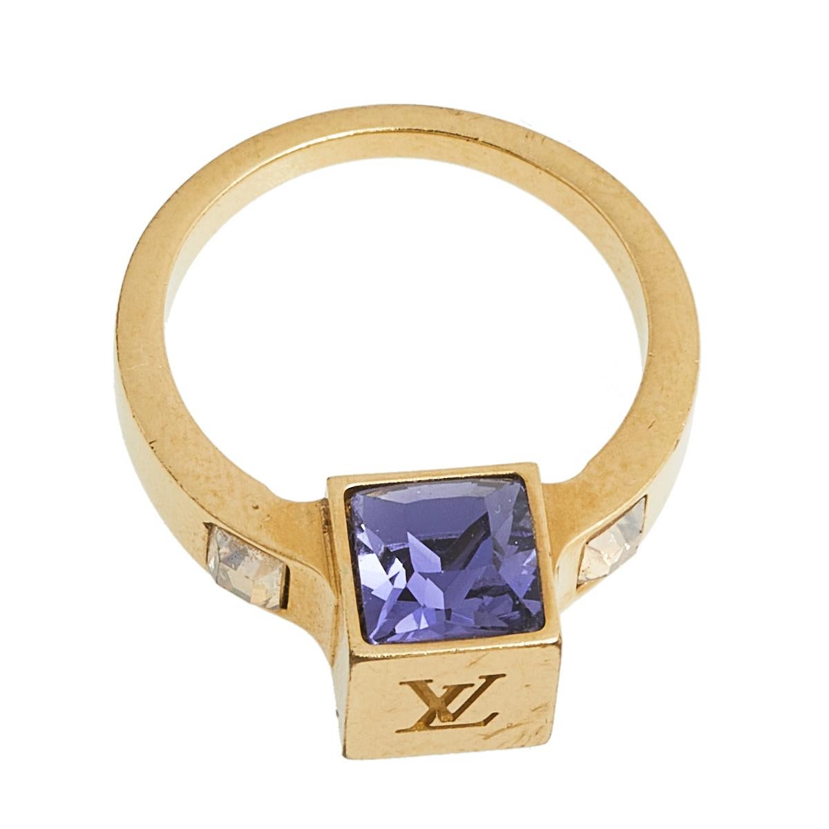 Artfully made from gold-tone metal, this flawless ring by Louis Vuitton can be your next prized possession. It features a gorgeous cube centerpiece with LV engraving and dazzling crystal embellishments. You're surely going to love this