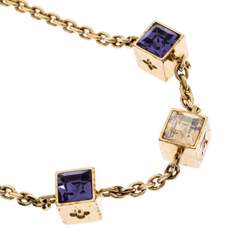 Made out of gold-tone metal, this flawlessly crafted bracelet by Louis Vuitton can be your next prized possession. The bracelet features a chain holding crystal-set cubes. The creation is finished with the signature LV letter charm and a lobster