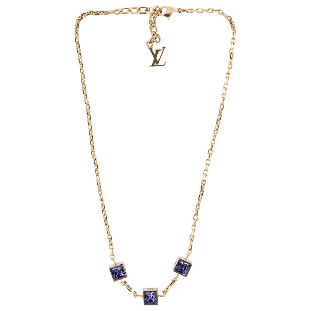 Made out of gold-tone metal, this flawlessly crafted necklace by Louis Vuitton can be your next prized possession. Featuring a gorgeous set of 3 crystal cubes, the design has been finished with the signature LV letters and a lobster clasp. You can