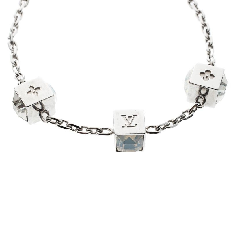 Artfully made from silver-tone metal, this flawless bracelet by Louis Vuitton can be your next prized possession. Featuring a gorgeous set of 3 cubes with monogram engravings and crystals, the design has been finished with the signature LV logo and