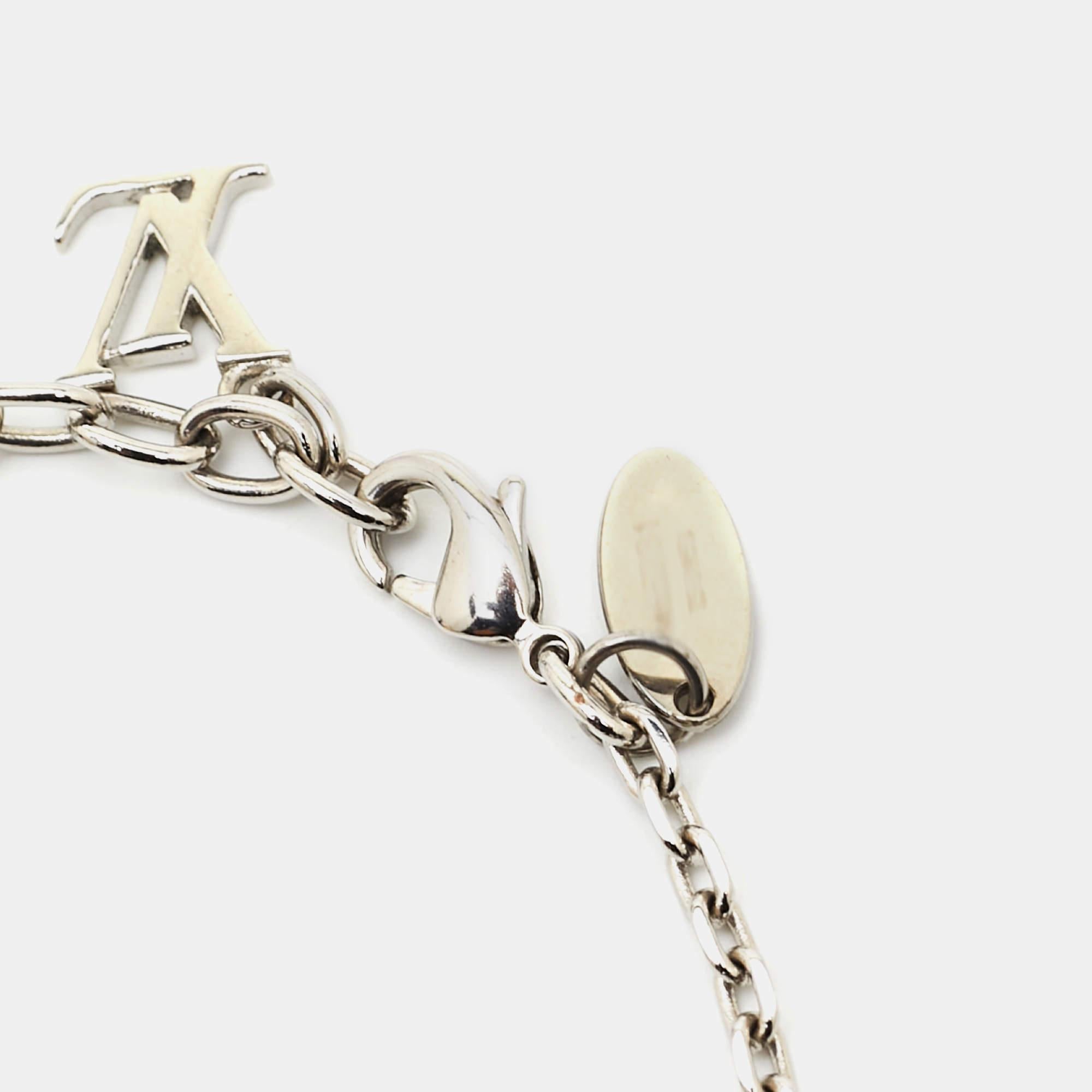 Made out of silver-tone metal, this flawlessly crafted bracelet by Louis Vuitton can be your next prized possession. The bracelet features a chain holding crystal-set cubes. The creation is finished with the signature LV letter charm and a lobster