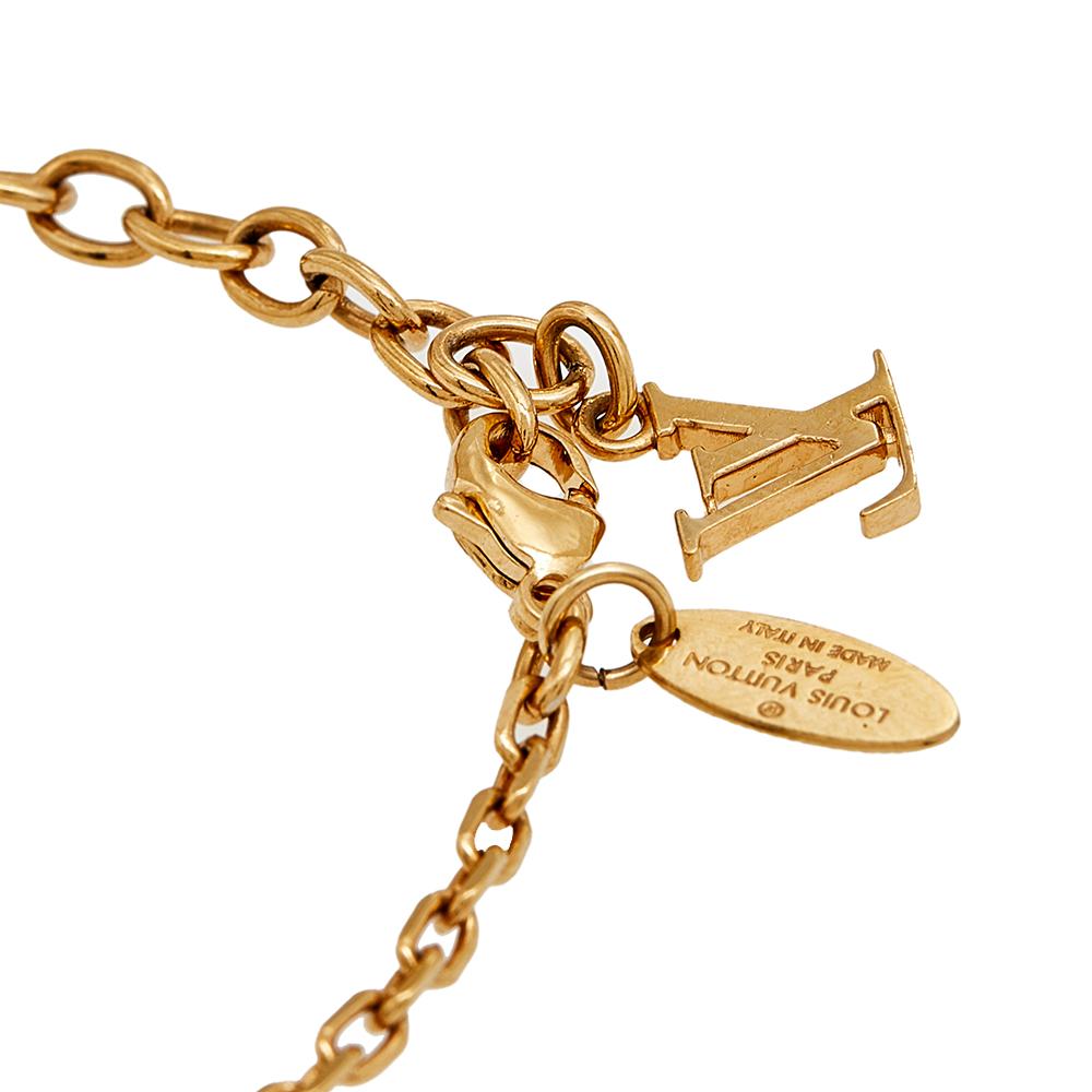 Artfully made from gold-tone metal, this flawless bracelet by Louis Vuitton can be your next prized possession. Featuring a gorgeous set of three cubes with monogram engravings and crystals, the design has been finished with the signature LV logo