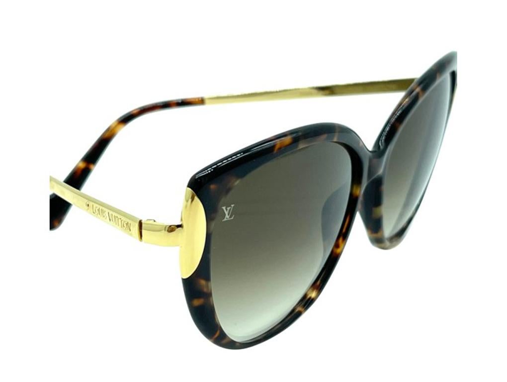 Exquisite pair of Louis Vuitton sunglasses with gold detail on the sides. These stylish sunglasses have classic cat eye rims in brown with lenses that are a shade of browny/black. The arms have Louis Vuitton embossed in brass.

BRAND	
Louis
