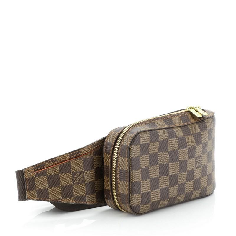 This Louis Vuitton Geronimos Waist Bag Damier, crafted from damier ebene coated canvas, features an adjustable canvas belt strap and gold-tone hardware. Its zip closure opens to an orange fabric interior. Authenticity code reads: CA1005. 

Estimated