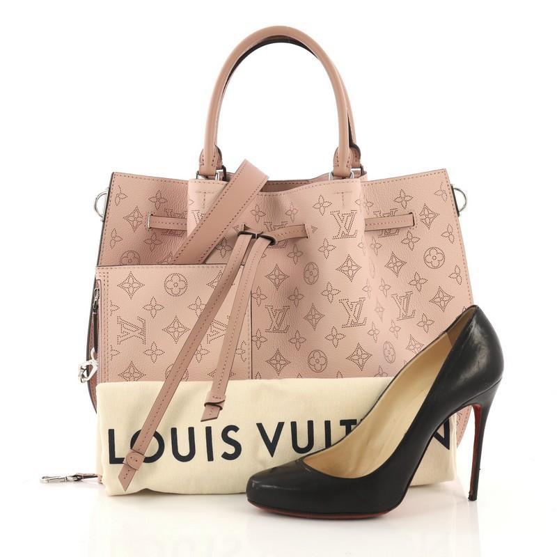 This Louis Vuitton Girolata Handbag Mahina Leather, crafted in light pink monogram mahina leather, features dual rolled leather handles, protective base studs, and silver-tone hardware. Its drawstring leather closure opens to a light pink microfiber