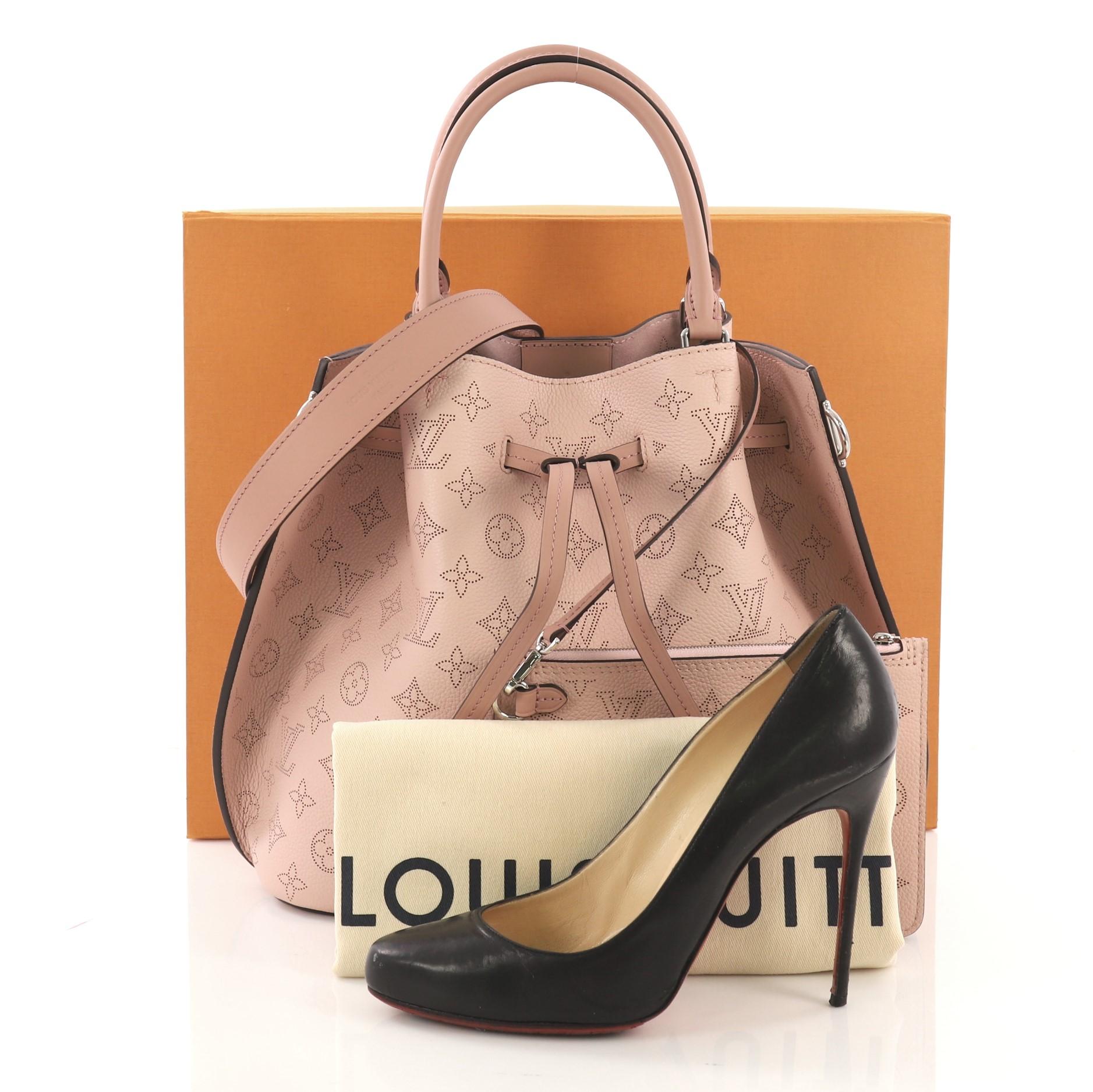 This Louis Vuitton Girolata Handbag Mahina Leather, crafted in light pink monogram mahina leather, features dual rolled leather handles, protective base studs, leather trim, and silver-tone hardware. Its leather drawstring closure opens to a light