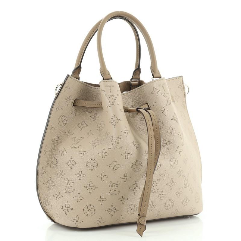 This Louis Vuitton Girolata Handbag Mahina Leather, crafted in neutral monogram mahina leather, features dual rolled leather handles, protective base studs, and silver-tone hardware. Its drawstring closure opens to a neutral microfiber interior with