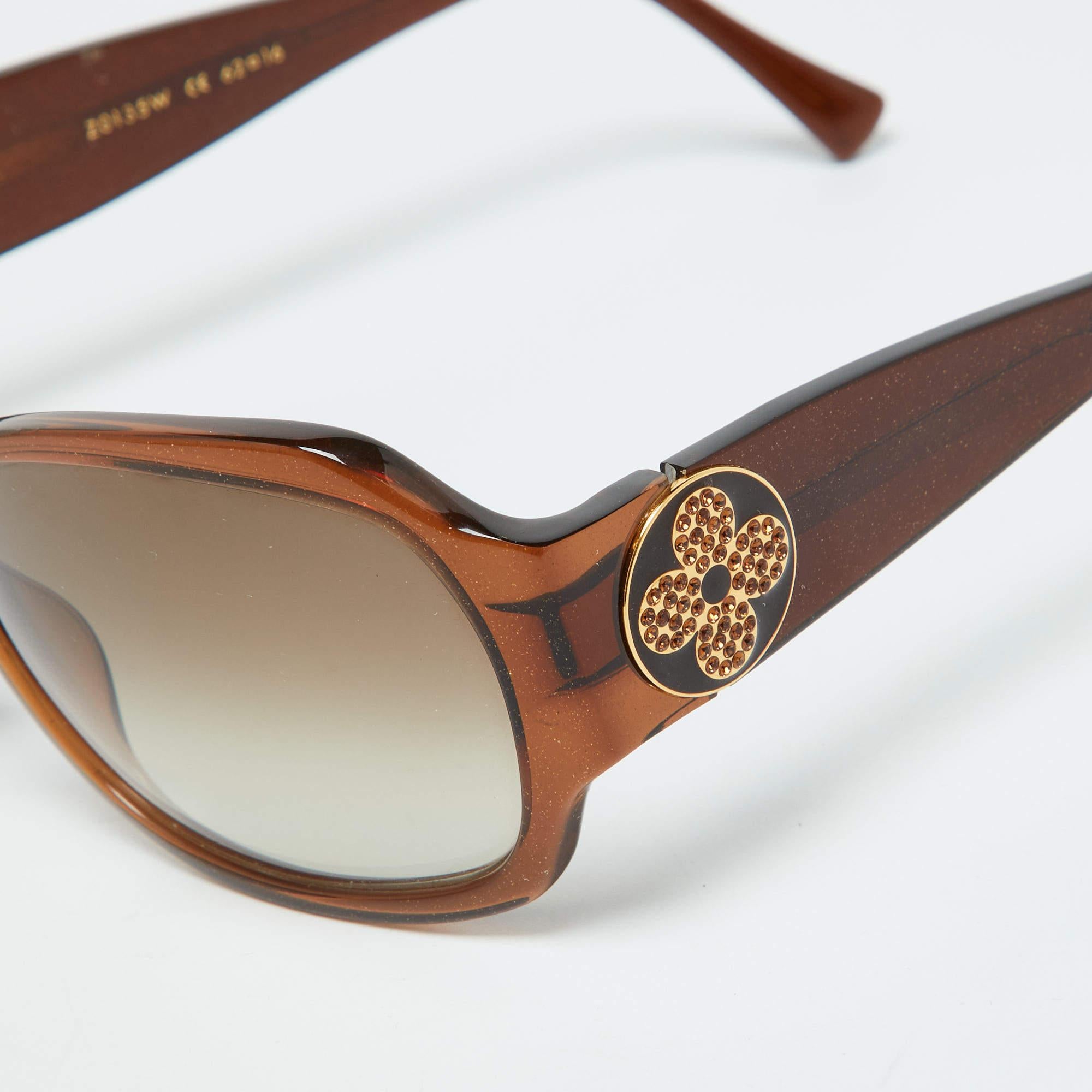 Enjoy those sunny days in full style while keeping your eyes safe with these Louis Vuitton brown sunglasses. The pair has an oversized frame fitted with high quality lenses and embellished brand flowers.