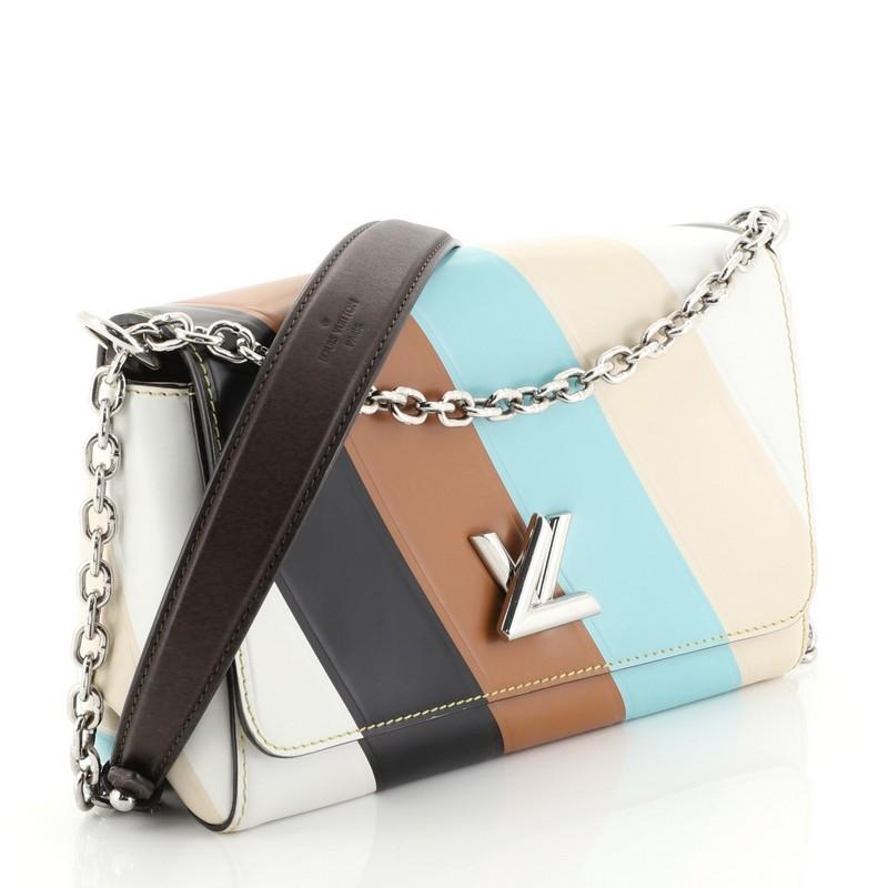 This Louis Vuitton GO-14 Handbag Striped Leather PM, crafted from white, black, brown and multicolor striped leather, features a chain link strap with leather pad and silver-tone hardware. Its twist-lock closure opens to a neutral leather interior