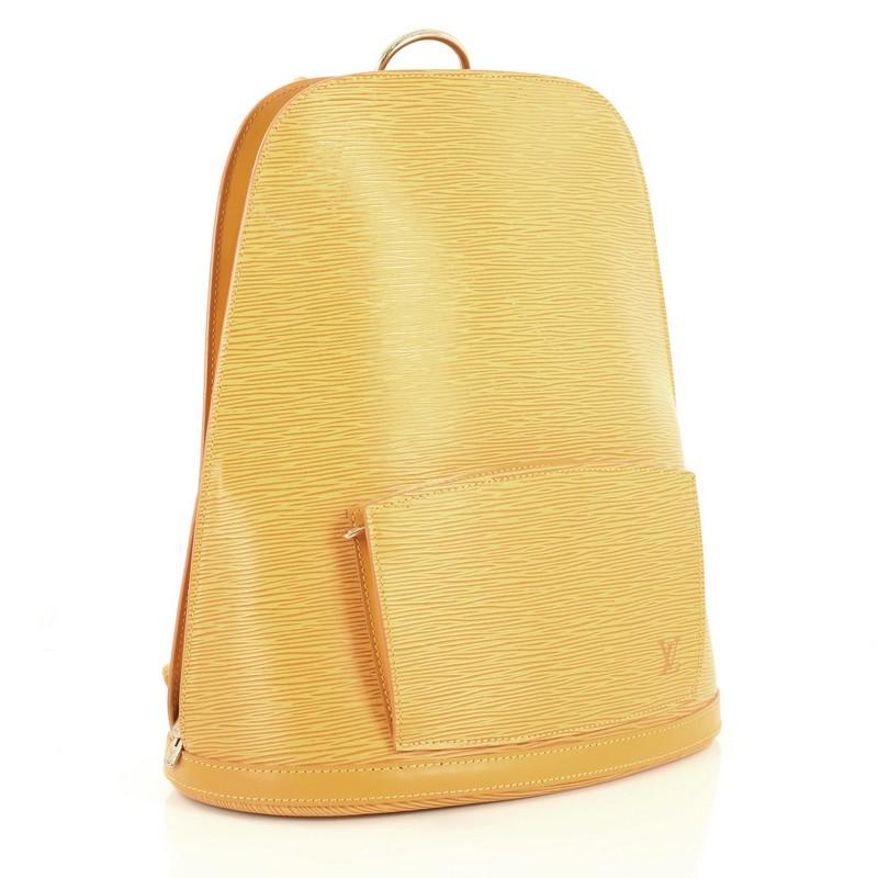 This Louis Vuitton Gobelins Backpack Epi Leather, crafted from yellow epi leather, features exterior front zip pocket, dual adjustable shoulder straps, oversized D-ring top handle, and gold-tone hardware. Its all-around zip closure opens to a purple