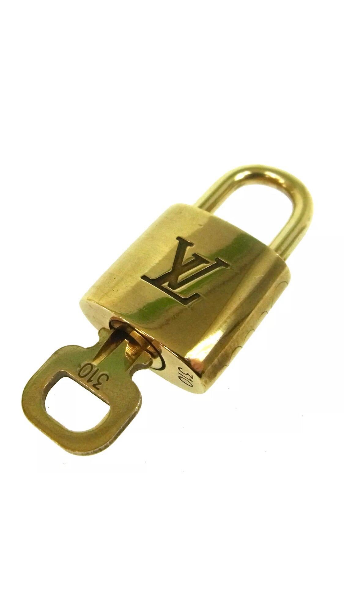 Louis Vuitton Gold Logo Travel Cosmetic Handbag Duffle Vanity Padlock and Key

Brass
Gold tone
Made in France
Measures 0.75” W x 1.5” H
Includes one padlock and one key
Actual padlock number and key may differ from shown
