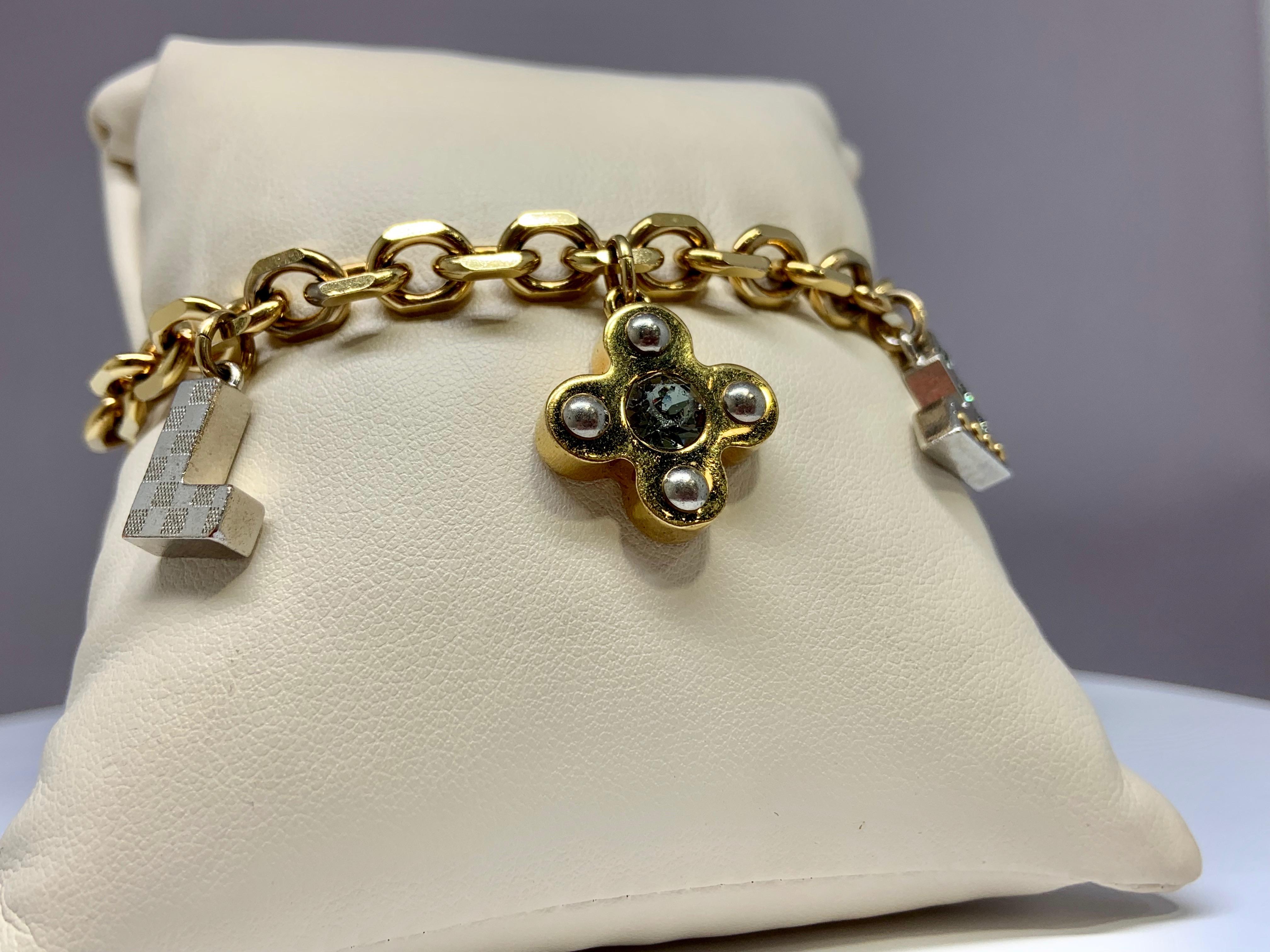This gently used Louis Vuitton charm bracelet is gold plated and includes 3 large charms. The bracelet is 8.5 inches long and includes a large lobster claw clasp for ultimate security. This bracelet features 4 Cubic Zirconia stones on 2 of the three