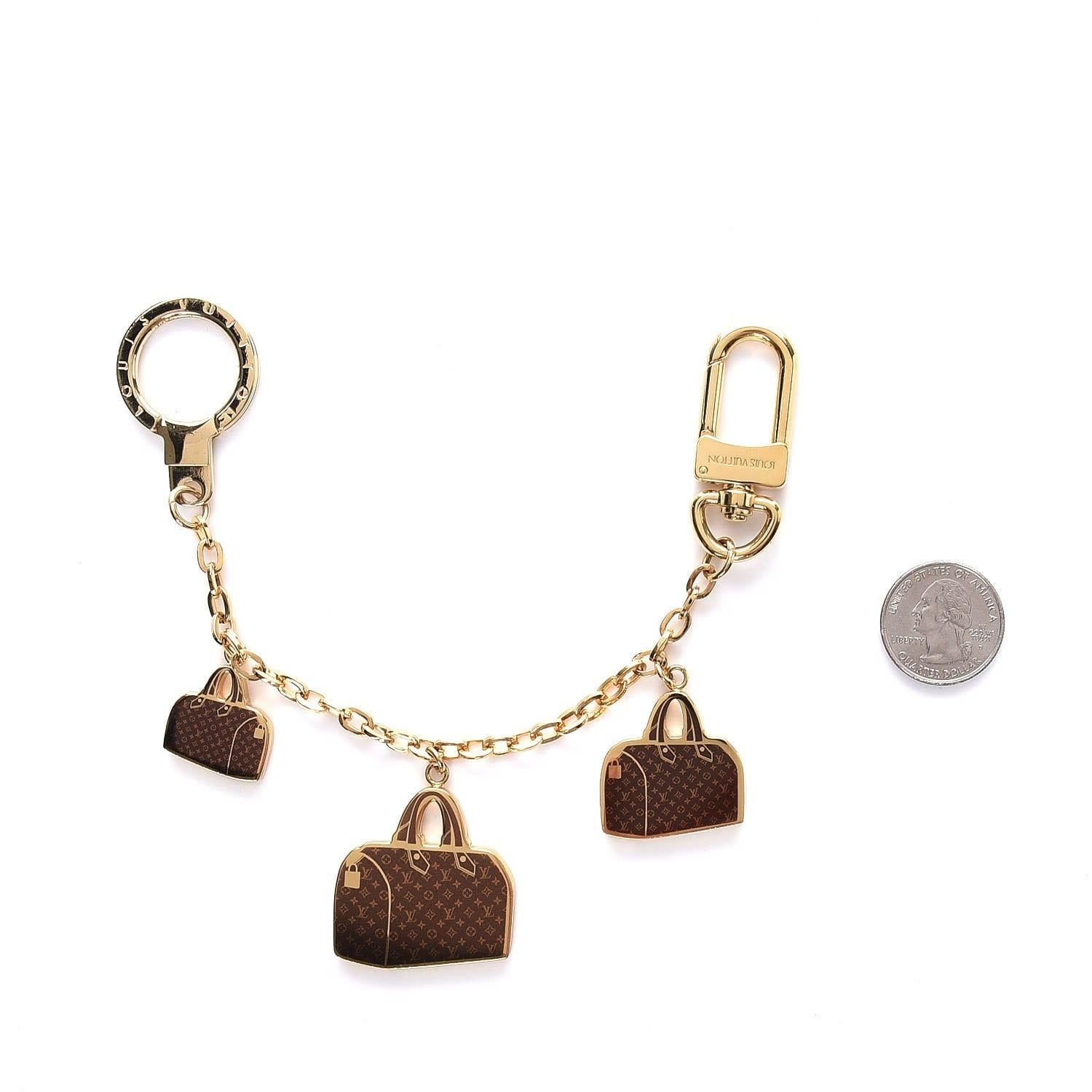 LOUIS VUITTON GOLD SPEEDY BAG CHARM CHAIN POCHETTE EXTENDER

This Louis Vuitton bag charm is crafted from polished gold-tone brass and features three miniature Monogram Speedy bag emblems. It is designed with a D-ring clasp on one end and a key ring