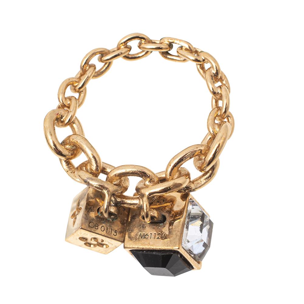 Artfully made from gold-tone metal, this flawless ring by Louis Vuitton can be your next prized possession. It features a chainlink band holding gorgeous cube centerpieces with the LV engraving and dazzling crystal embellishments. You're surely