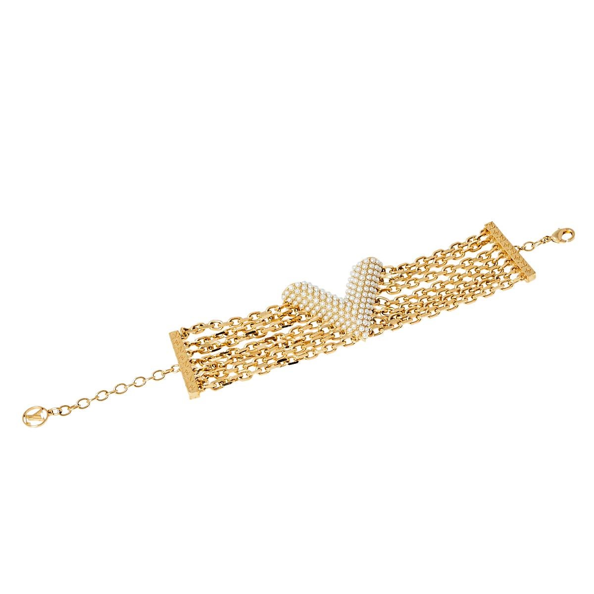 Create an elegant, timeless, and classic addition to both casual and even special events with this beautiful Louis Vuitton Essential V Perle bracelet. Constructed in gold-tone metal, this bracelet features a large V motif in the center detailed with