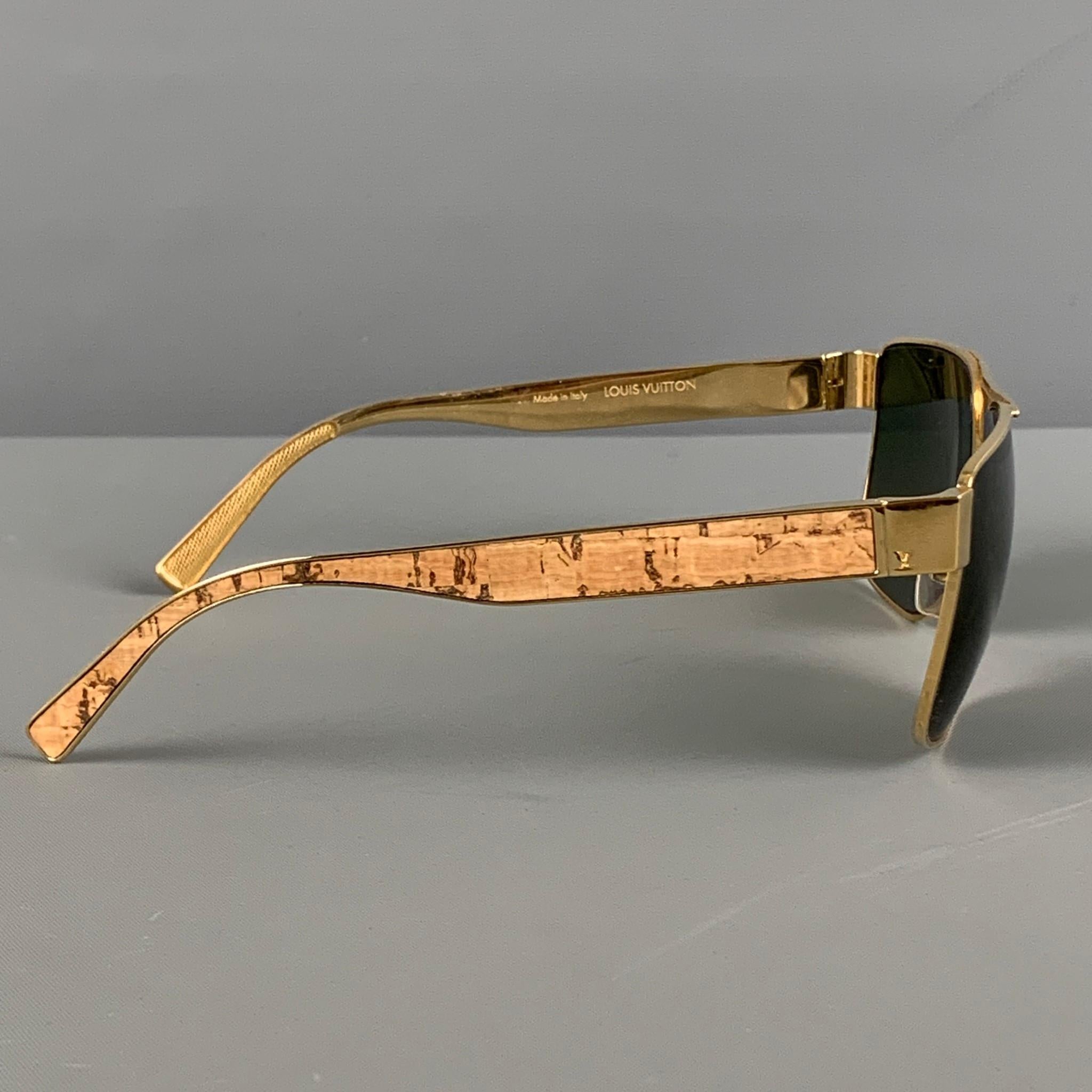 LOUIS VUITTON sunglasses comes in a gold tone metal with a wood grain trim featuring tinted lenses. Includes case. Made in Italy. 

Very Good Pre-Owned Condition.
Marked: Z0797U 948 57-17 140 S0126

Measurements:

Length: 14 cm.
Height: 5 cm. 