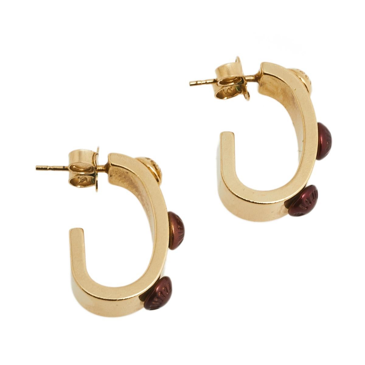 This pair of Gimme A Clue earrings from the house of Louis Vuitton is crafted in gold-tone metal and features red enameled beads all around the hoop style.