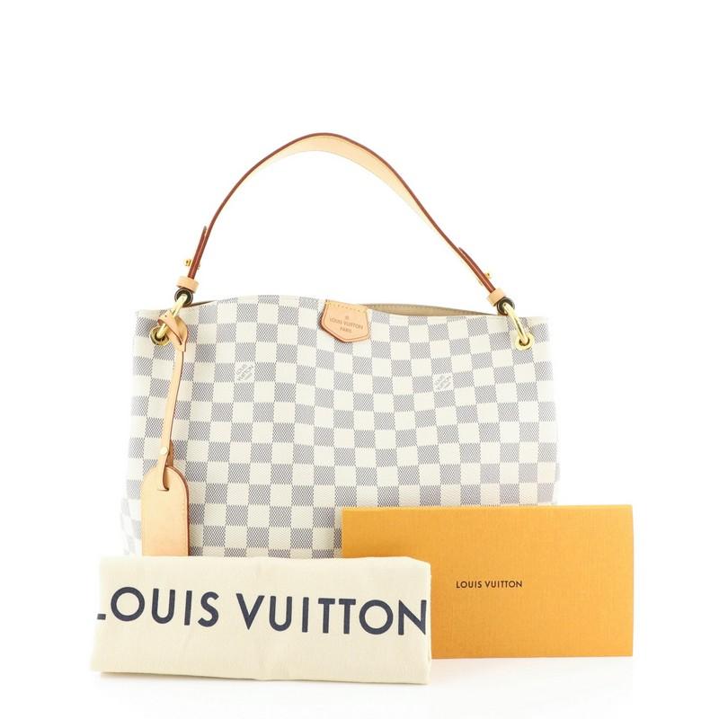 This Louis Vuitton Graceful Handbag Damier PM, crafted in damier azur coated canvas, features a flat leather shoulder strap, leather trim, and gold-tone hardware. Its magnetic closure opens to a neutral fabric interior with zip pocket. Authenticity
