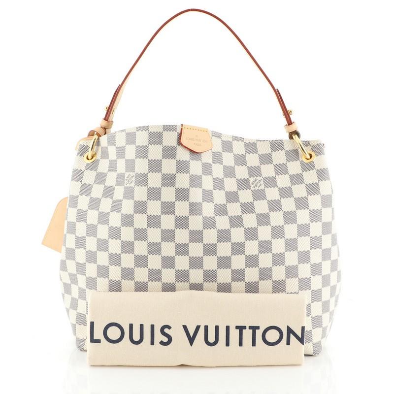 This Louis Vuitton Graceful Handbag Damier PM, crafted in damier azur coated canvas, features a flat leather shoulder strap, leather trim, and gold-tone hardware. Its magnetic closure opens to a neutral fabric interior with zip pocket. Authenticity