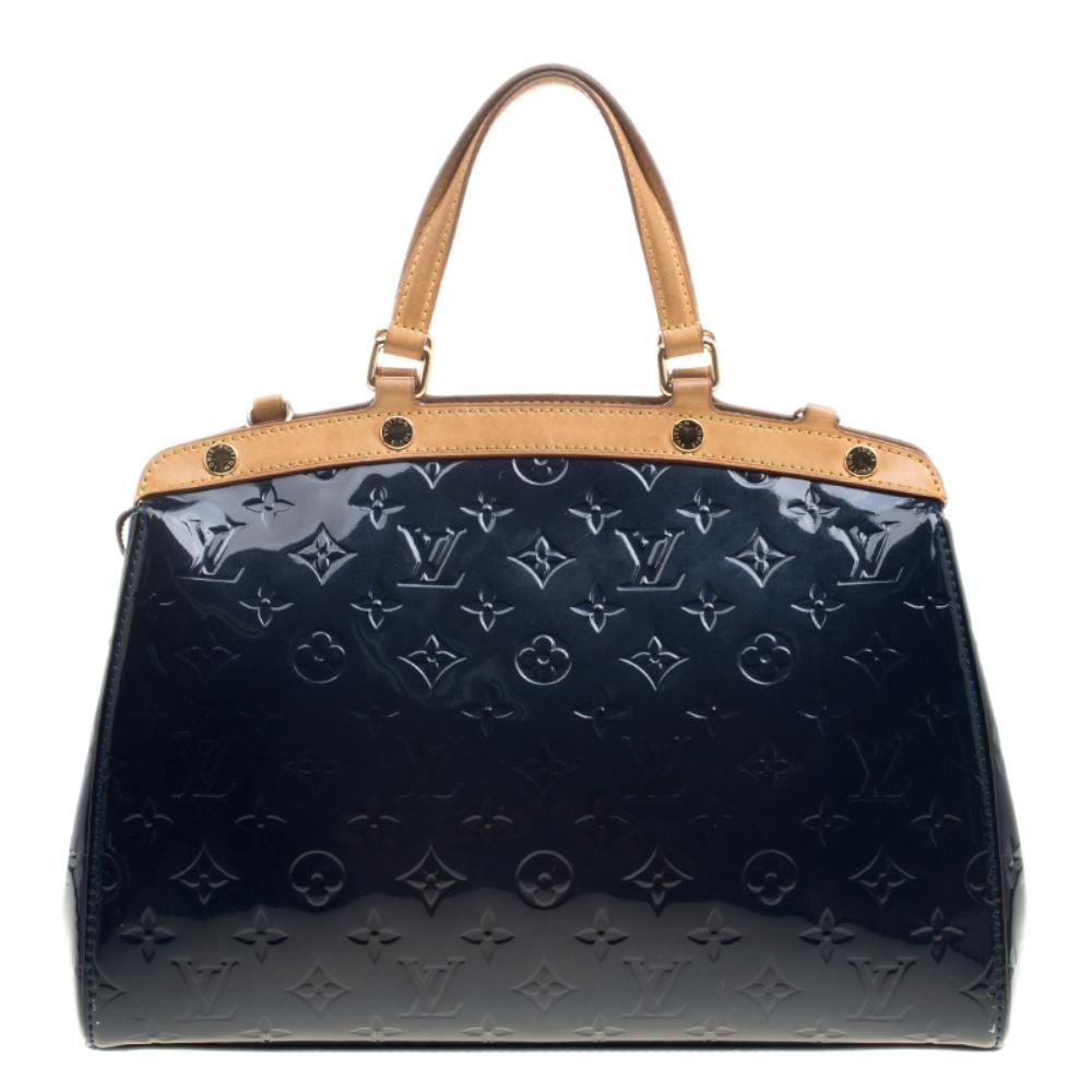 The feminine shape of Louis Vuitton's Brea is inspired by the doctor's bag. Crafted from their signature Vernis leather in grand blue, the bag has a perfect finish. The fabric-lined interior is spacious and it is secured by a zipper. The bag