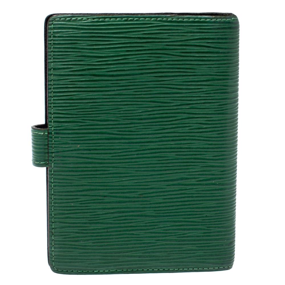 This Agenda cover from the house of Louis Vuitton has been designed using Epi leather and is secured by a snap button closure. It opens to reveal small rings at the center and slots on either side to hold your notes, bills, cards, and other little