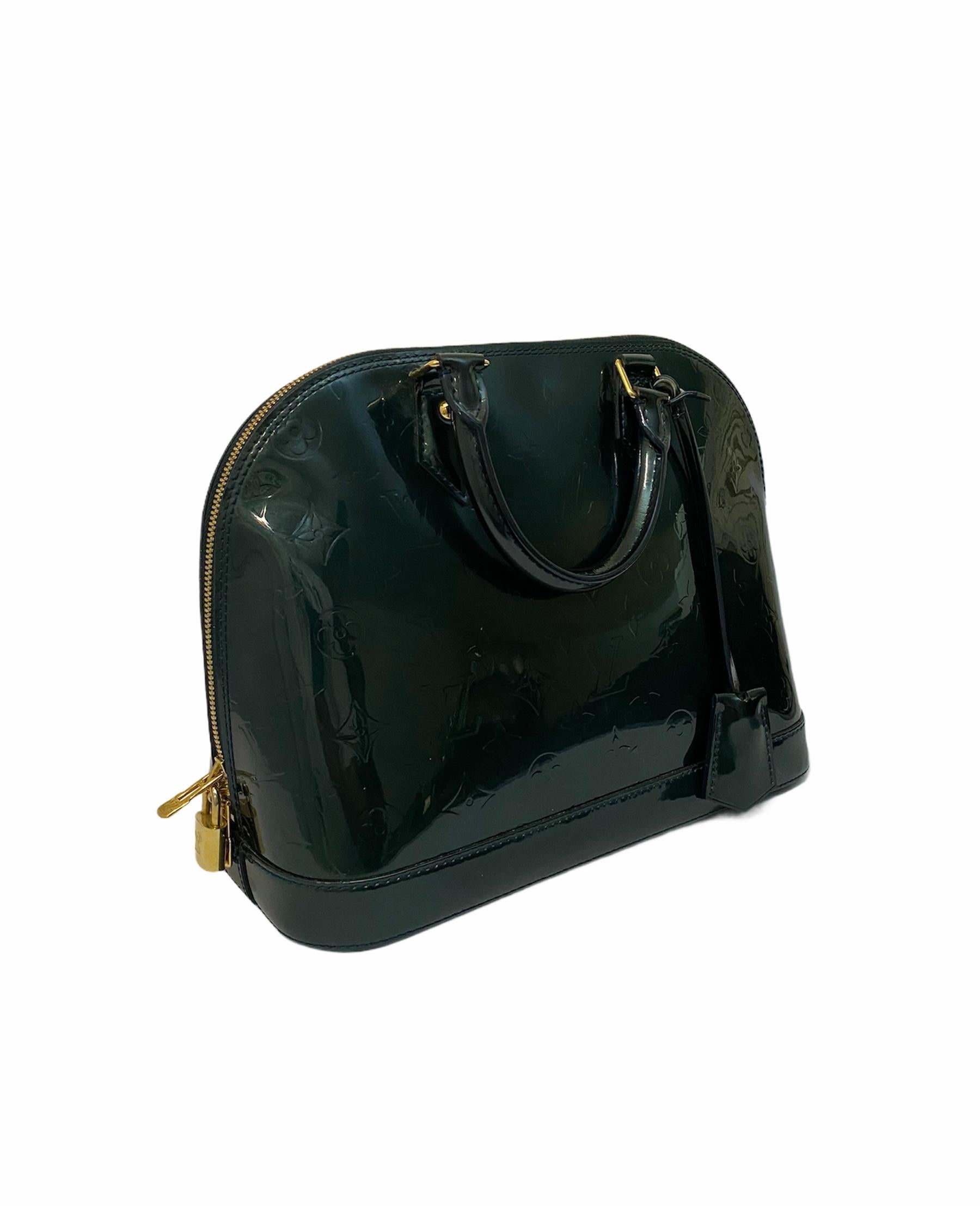 Louis Vuitton Tasche, Modell Alma MM, aus flaschengrünem Lackleder mit goldenen Beschlägen.

Ausgestattet mit einem Reißverschluss, innen gefüttert mit grünem Segeltuch, recht geräumig.

Präsentiert zwei starre Griffe in Farbe, Innentaschen und