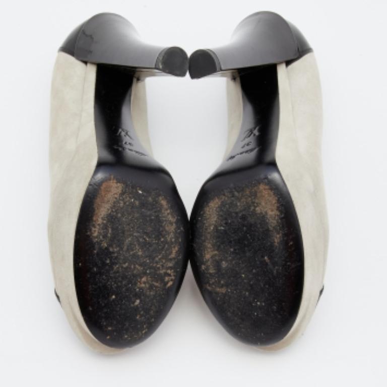 Faites chaque pas avec élégance et style grâce à ces escarpins de la maison Louis Vuitton. Elles sont confectionnées avec soin en daim gris-noir et en cuir verni. Ils sont dotés de plateformes, de peep toes et de talons de 13,5 cm. Ces escarpins
