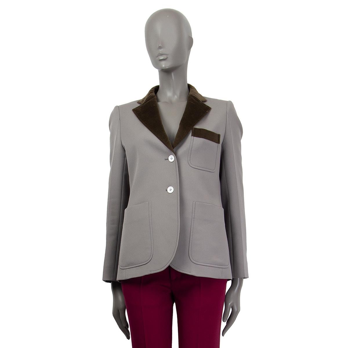Louis Vuitton long-cut blazer in grey polyester with olive green velvet collar and check pocket trim. Has white buttons and three patch pockets. Lined in viscose (50%) and cupro (50%). Has been worn and is in excellent condition.

Tag Size 38
Size
