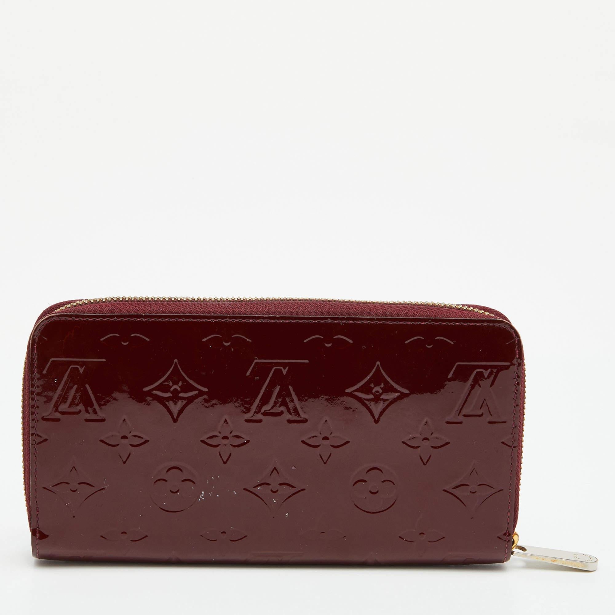 This Louis Vuitton Zippy wallet is conveniently designed for everyday use. Crafted from Griotte Monogram Vernis canvas, it is paired with a zip-around closure and gold-tone hardware. The compartmentalized interior of the wallet will store your card