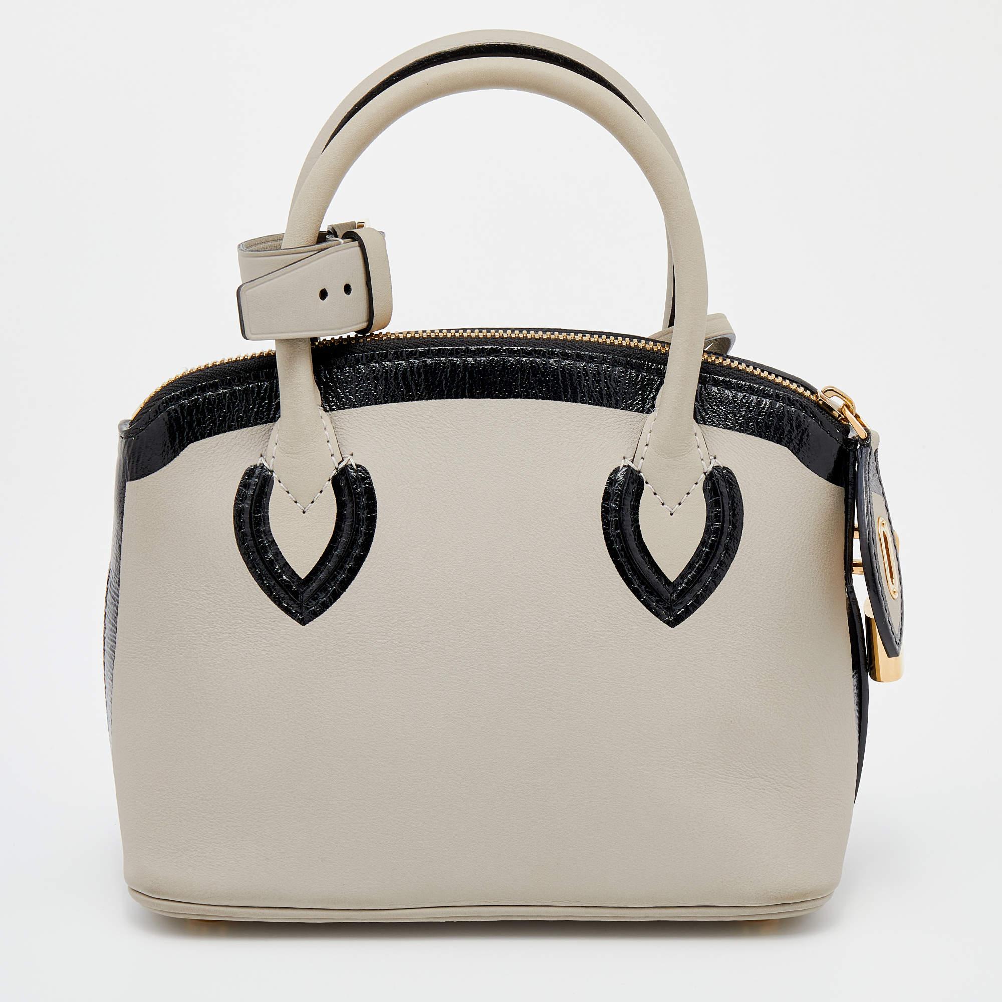 Influenced by the iconic padlock and key, the Louis Vuitton Lockit BB bag embodies classic aesthetics and a sophisticated appeal. This bag is functional in size and is appealing with contrasting trims. Lined with leather, the interior is made secure