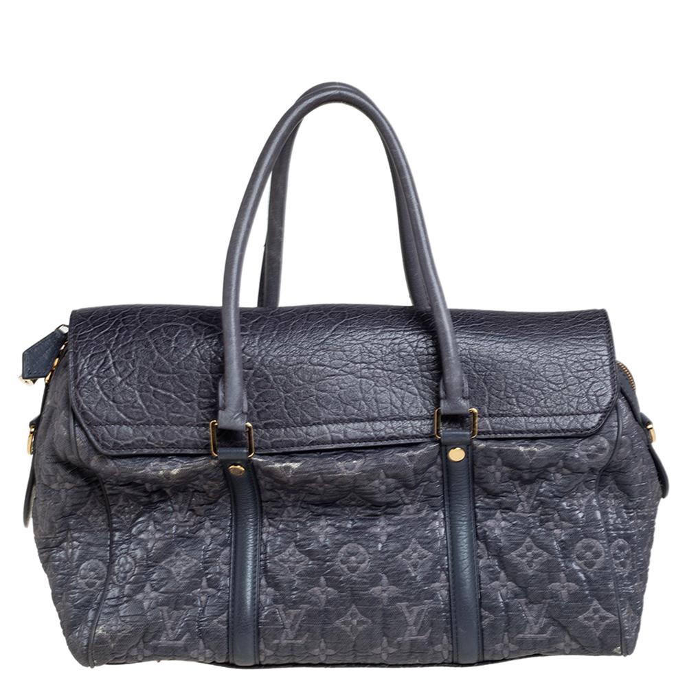 This bag is from Louis Vuitton's Fall/Winter 2010 Runway Collection. It is a limited edition piece made from monogram coated canvas and detailed with a leather flap. On top, there are two handles and on the base, there are four metal