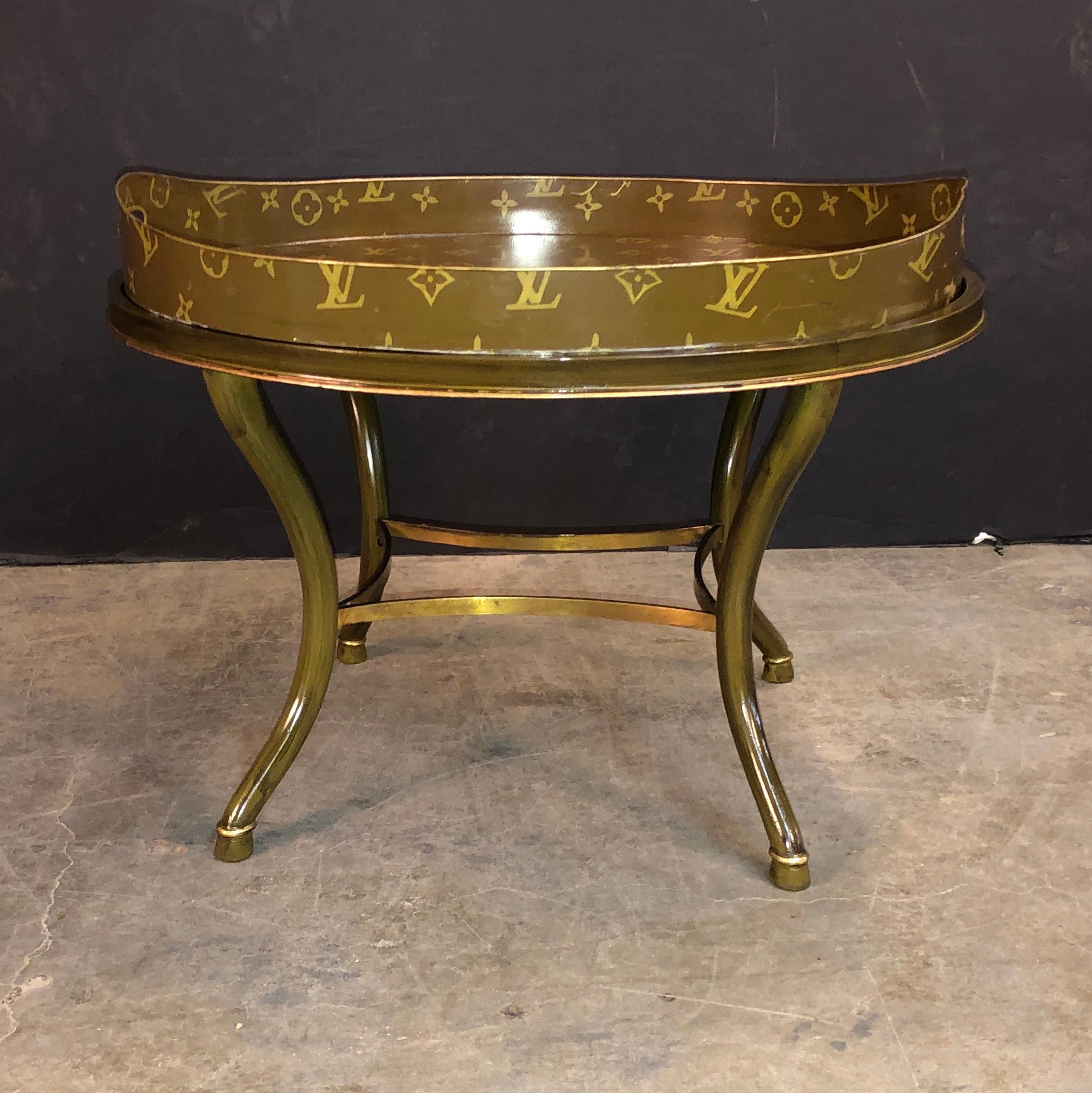 A wonderful antique European tray hand painted with the design motif and logo of Louis Vuitton. The matching base is also a later addition to the tray.