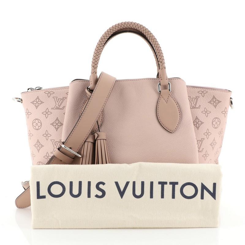 This Louis Vuitton Haumea Handbag Mahina Leather, crafted from pink mahina leather, features, dual braided handles and silver-tone hardware. Its zip closure opens to a brown microfiber interior with zip and slip pockets. Authenticity code reads: