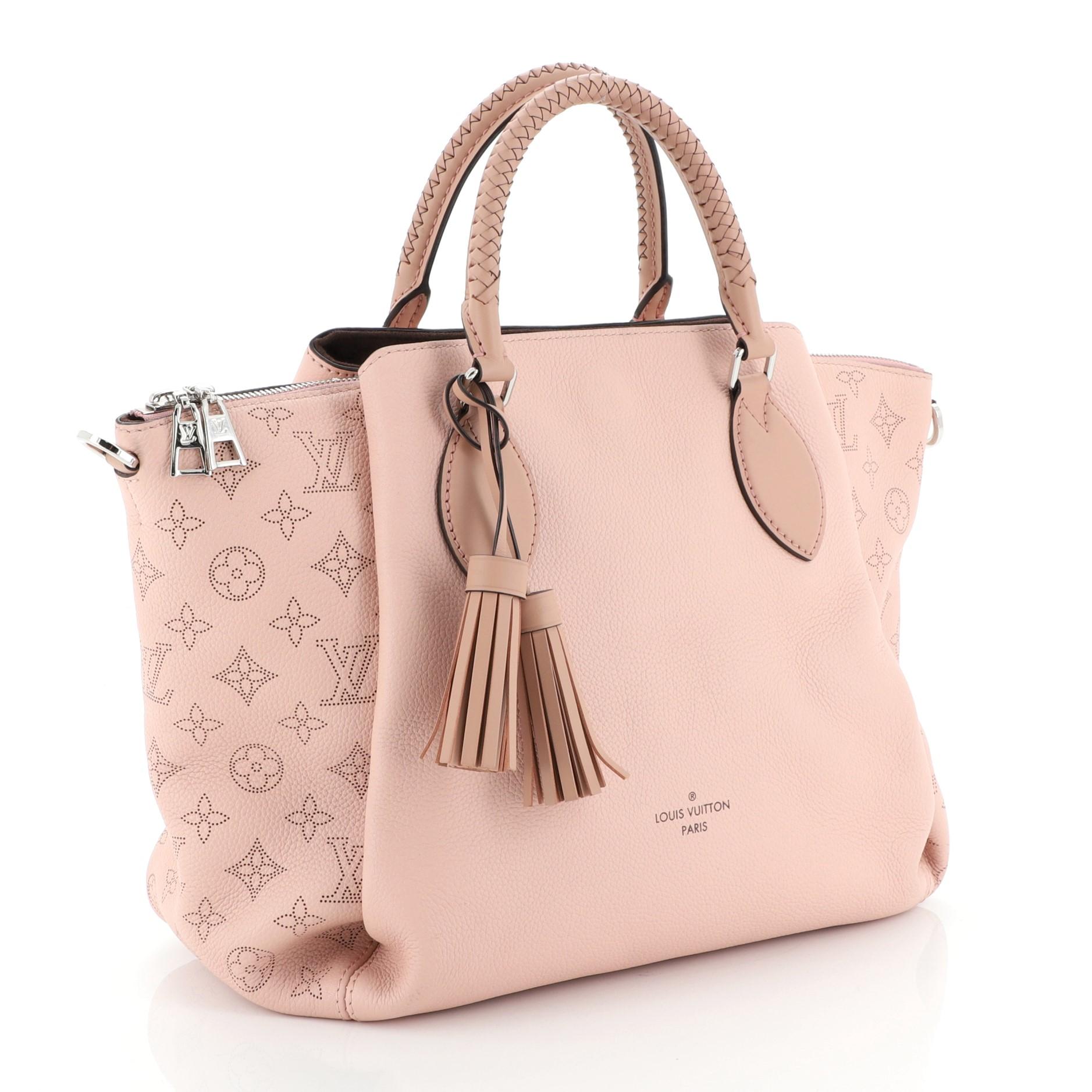 This Louis Vuitton Haumea Handbag Mahina Leather, crafted from pink mahina leather, features, dual braided handles and silver-tone hardware. Its zip closure opens to a brown microfiber interior with zip and slip pockets. Authenticity code reads: