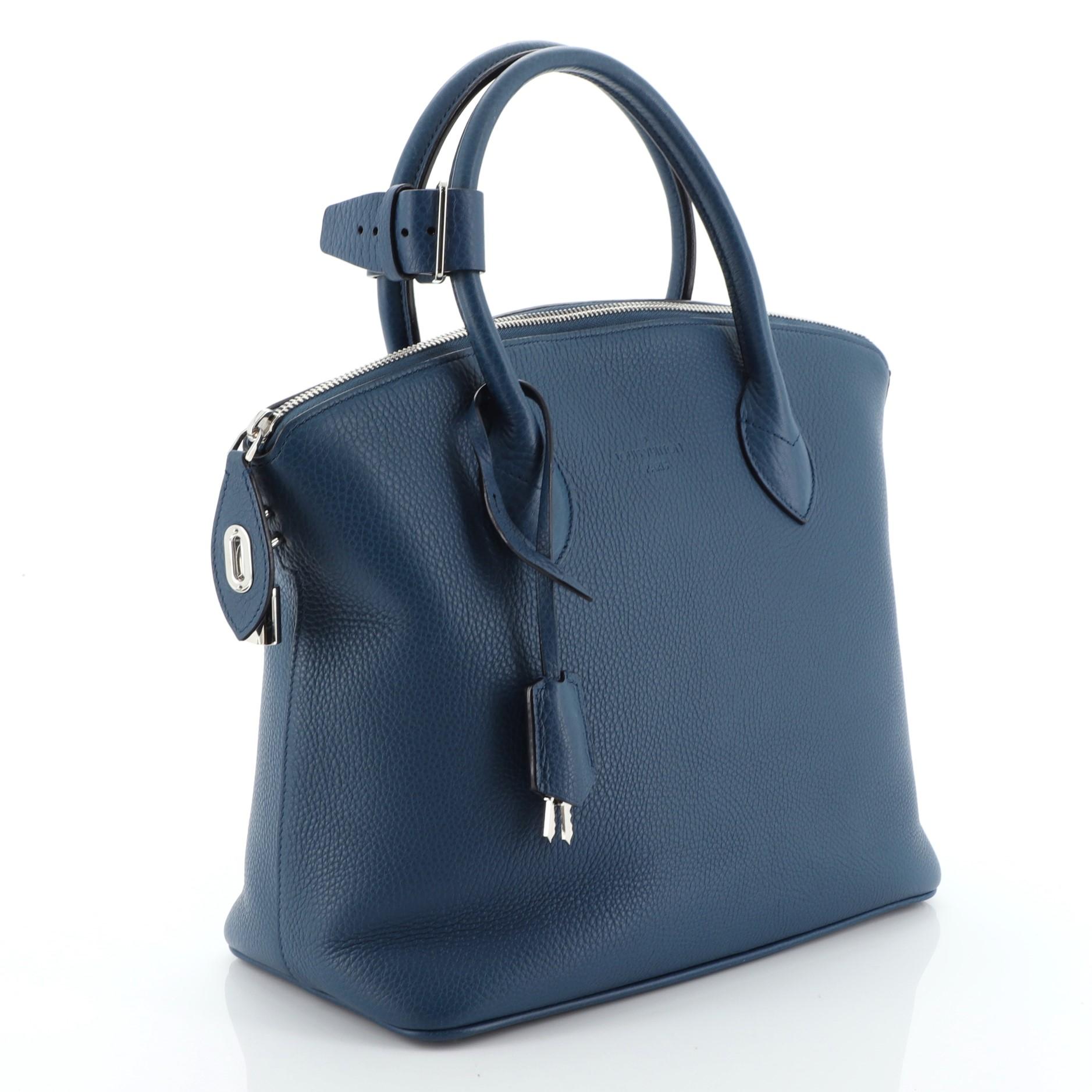 This Louis Vuitton Haute Maroquinerie Lockit Handbag Leather PM, crafted in blue leather, features dual rolled leather handles, protective base studs and silver-tone hardware. Its zip closure opens to a blue leather interior with zip and slip