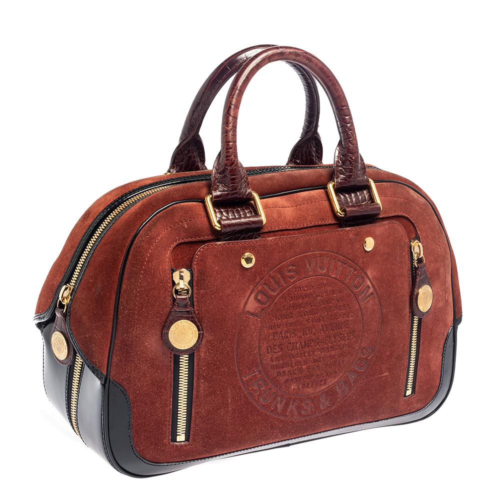 Let this limited edition Stamped Trunk bag from Louis Vuitton add the touch of luxury to your style! Crafted from suede and enhanced with alligator embossing and patent leather, the piece features a signature stamp on the front. It has a well-sized