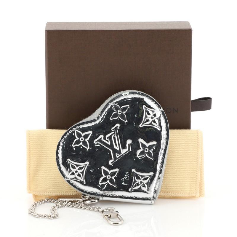 This Louis Vuitton Heart Coin Purse Miroir PVC, crafted in silver PVC, features silver-tone hardware. Its zip closure opens to a silver leather interior. Authenticity code reads: TH1048. 

Estimated Retail Price: $545
Condition: Great. Small glue