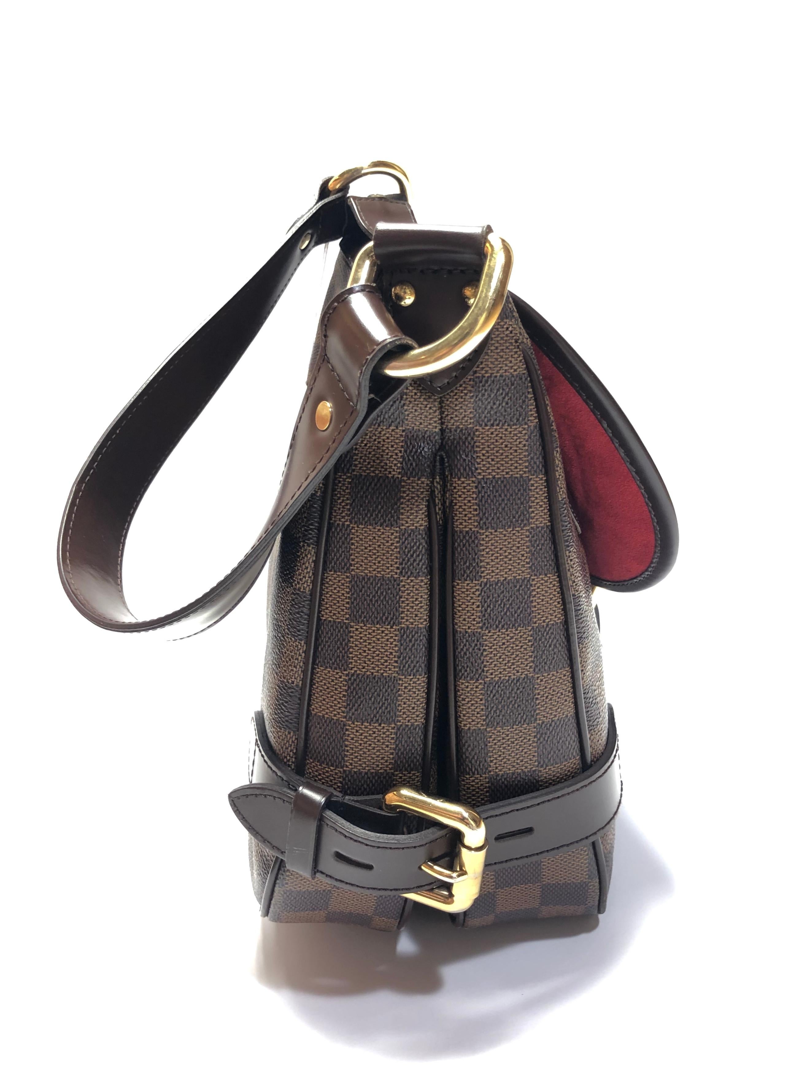 Brown and tan Damier Ebene coated canvas Louis Vuitton Highbury bag with brass hardware, Moka leather trim, single flat shoulder strap, single flap pocket with buckle closure at front, crimson Alcantara lining, dual interior compartments, dual