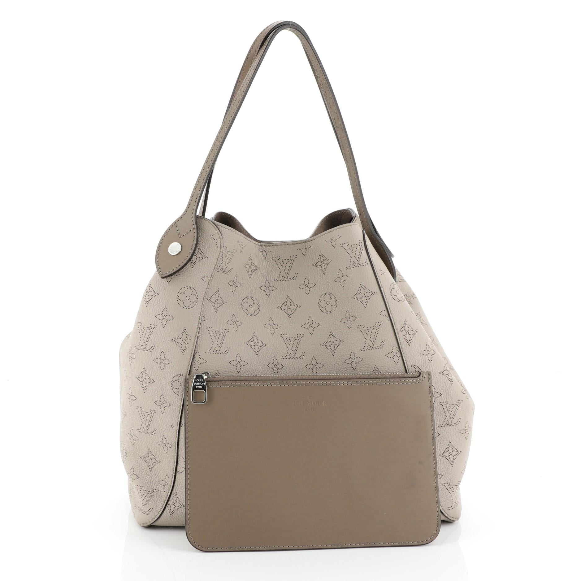 This Louis Vuitton Hina Handbag Mahina Leather MM, crafted from neutral mahina leather, features dual slim leather handles and silver-tone hardware. Its magnetic snap button closure opens to a neutral microfiber interior. Authenticity code reads: