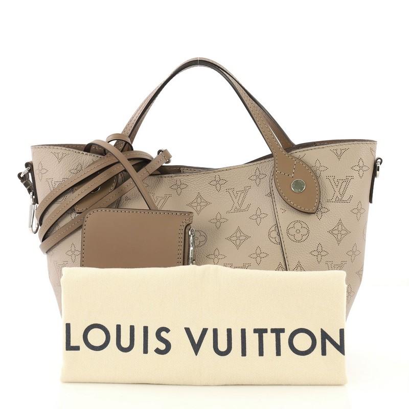 This Louis Vuitton Hina Handbag Mahina Leather PM, crafted from taupe mahina leather, features dual slim leather handles, and silver-tone hardware. Its magnetic snap button closure opens to a brown microfiber interior. Authenticity code reads: