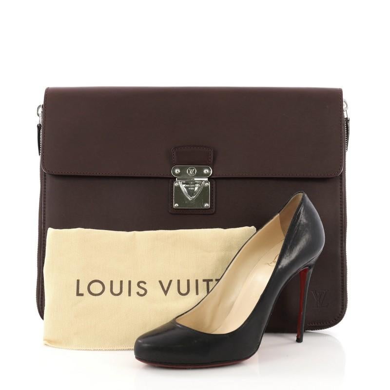 This Louis Vuitton Honore Portfolio Nomade Leather, crafted in burgundy nomade leather, features frontal flap with push-lock closure and silver-tone hardware. It flap and zip closure opens to a brown microfiber interior with slip pockets. **Note: