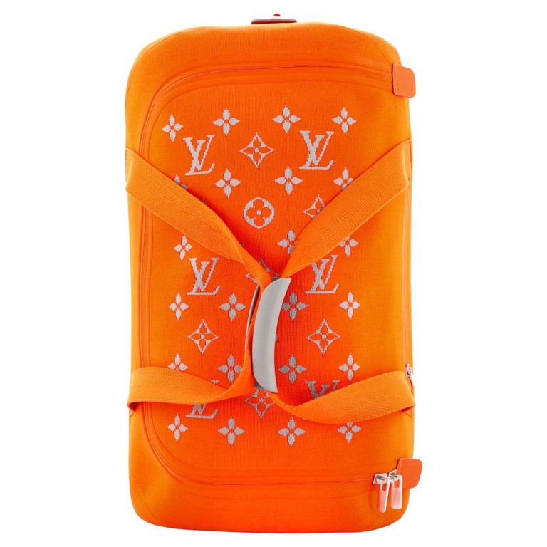 A guest wears an orange LV monogram print pattern carrot bag as an