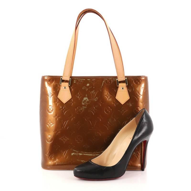 This authentic Louis Vuitton Houston Handbag Monogram Vernis is a stylish and functional bag made for everyday use. Crafted from bronze monogram vernis leather, this tote features dual flat tall vachetta leather handles, vachetta leather trims, and