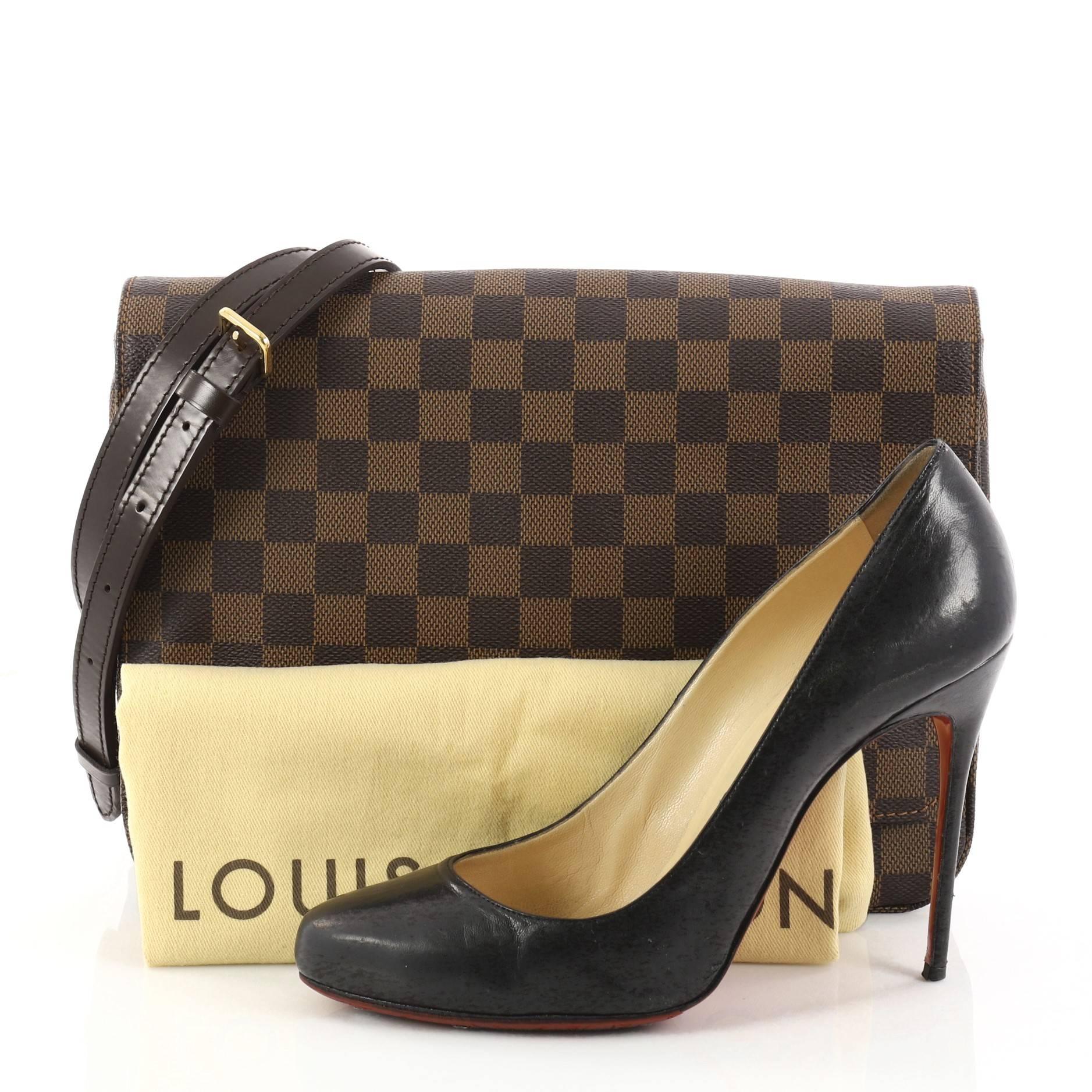 This authentic Louis Vuitton Hoxton Handbag Damier GM is a beautiful messenger bag ideal for daily use. Crafted from damier ebene coated canvas, this bag features adjustable shoulder strap, exterior back zip pocket and gold-tone hardware accents.