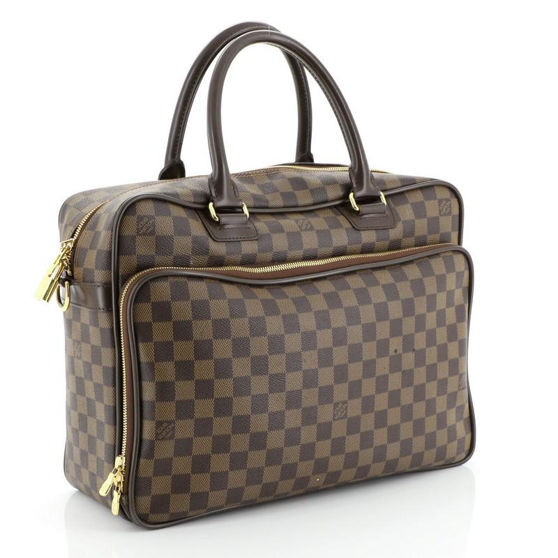 This Louis Vuitton Icare Laptop Bag Damier, crafted from damier ebene coated canvas, features dual rolled leather handles, front zip pocket, and gold-tone hardware. Its zip closure opens to a brown fabric interior. Authenticity code reads: AS4140.