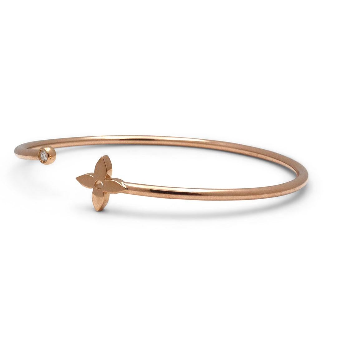 Authentic Louis Vuitton 'Idylle Blossom Twist' bracelet crafted in 18 karat rose gold.  The split bangle features the iconic Louis Vuitton monogram flower on one end and is bezel set with a round brilliant diamond weighing approximately .05 carats