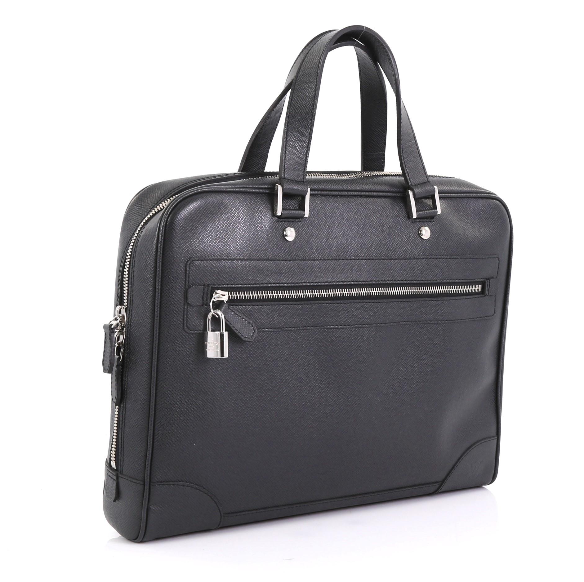 This Louis Vuitton Igor Briefcase Taiga Leather, crafted in black taiga leather, features dual flat leather handles, exterior zip pocket and silver-tone hardware. Its zip closure opens to a black fabric interior with zip and slip pockets.